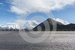 Empty asphalt highway with snow mountain background