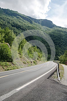 empty asphalt road and beautiful mountains covered with green vegetation Aurlandsfjord Flam