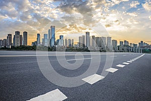 Empty asphalt road and city buildings skyline