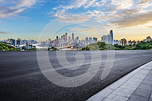 Empty asphalt road and city buildings skyline