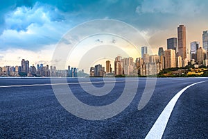 Empty asphalt road and city buildings skyline