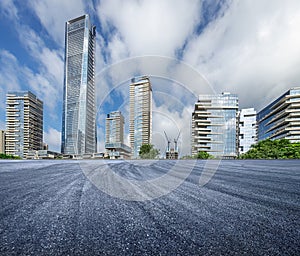 Empty asphalt road and city buildings skyline