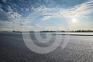 Empty asphalt road and city skyline