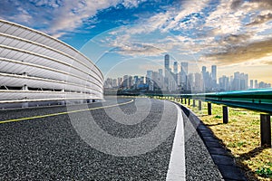 Empty asphalt road and city skyline