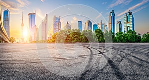 Empty asphalt road and city skyline