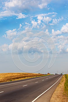 Empty asphalt road between flower meadows in the countryside.