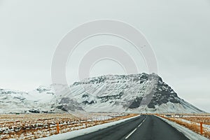 empty asphalt road and majestic snow-covered mountains