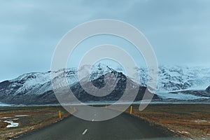 empty asphalt road and majestic snow-covered rocky mountains