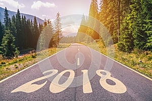 Empty asphalt road and New year 2018 concept. Driving on an empty road in the mountains to upcoming 2018 and leaving behind old 2