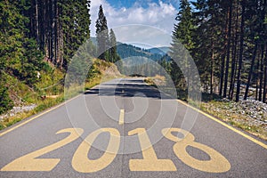 Empty asphalt road and New year 2018 concept. Driving on an empty road in the mountains to upcoming 2018 and leaving behind old 2