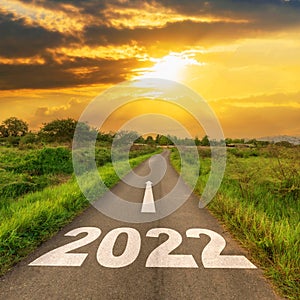 Empty asphalt road and New year 2022 concept. Driving on an empty road to Goals 2022 with sunset