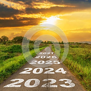 Empty asphalt road and New year 2023 concept. Driving on an empty road to 2023 with sunset