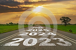 Empty asphalt road and New year 2023 concept. Driving on an empty road to 2023 with sunset