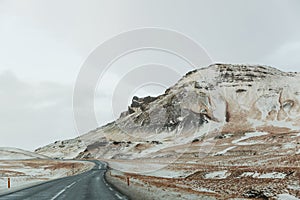 empty asphalt road and scenic snow-covered mountains