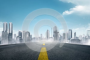 Empty asphalt road towards modern city