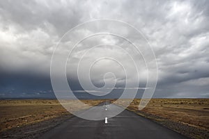Empty road under stormy dramatic sky