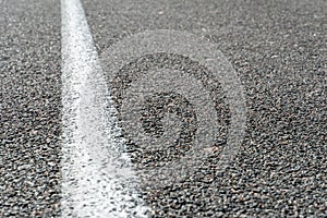 Empty asphalt road. New fresh asphalt pavement away from the city. Development of rural infrastructure. Road marking lines close