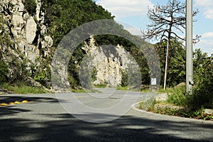 Empty asphalted road near steep cliff and trees