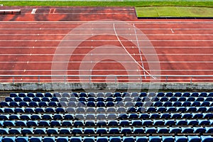 Empty auditorium in athletic stadium, rows of blue chairs