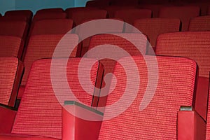 In the empty auditorium with red chairs