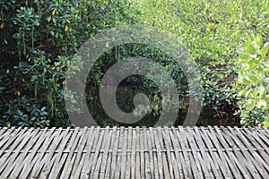 Empty Bamboo table in front of canal in the forest background. It can be used for display or montage product. Wooden terrace of