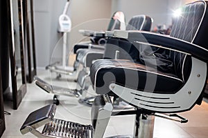 Empty barbershop, hairdresser`s interior, comfortable chairs and modern design, free and clean workplace