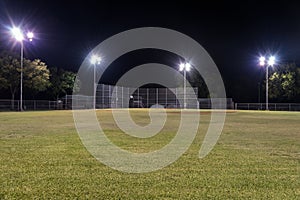 Empty baseball field at night with the lights on