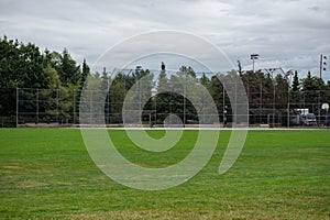 Empty baseball or softball diamond from the back fence and foul line looking towards the grass and trees in New Westminster,