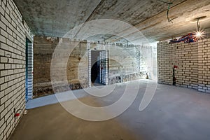 Empty basement room with minimal preparatory repairs. interior with white brick walls