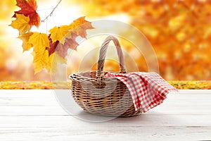 Empty basket with red napkin picnic on table place. Autumn background