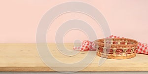 Empty basket with tablecloth on wooden table on old wall background, rustic style, eco concept, kitchen mockup for design and