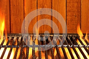 Empty BBQ Flaming Grill And Wood Wall In The Background