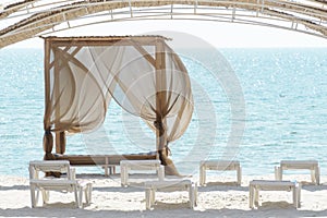 Empty beach beds. Lounge chaise on a sand shore,sun umbrellas omission, empty beach, summer