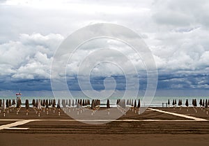 Empty beach in Caorle at the end of September under a heavy cloudy sky