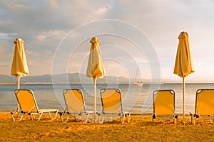 Empty beach chairs umbrella sun deck chairs beach lounge chair sea yacht beach sailboat sea shore sunset sail boat