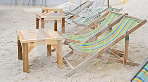 Empty beach chairs with wooden table on beach