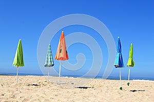 Empty beach with closed parasols