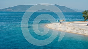 Empty beach in Greece with one sunshade