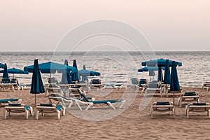 Empty beach, with hammocks and parasols, cloudy day