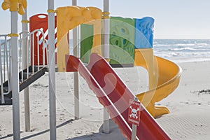 An empty beach, playground, a sign with the inscription - translated as - stop, mines