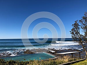 An empty beach in regional Australia with surf and salt water pool