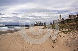 Empty Beach Sand Dunes and Vegetation Against City Skyline