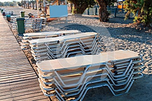 Empty beach with stacked sun loungers on the beach. Crete Greece.