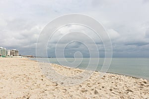 Empty beach before storm. Dramatic cloudscape. Autumn seascape. Calm weather on the seaside.