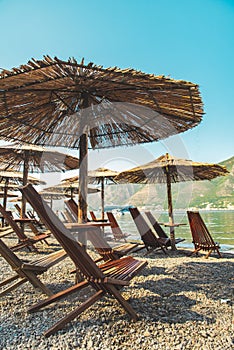 empty beach with sun loungers and umbrellas. sea with mountains