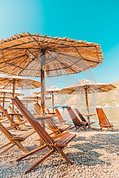 empty beach with sun loungers and umbrellas. sea with mountains