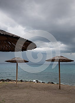 Empty beach umbrellas at a rocky coast in winter. Summer vacations Paphos Cyprus