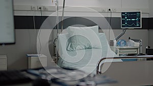 Empty bed in hospital ward with medical equipment