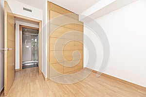 Empty bedroom with beech-colored three-door wardrobe, matching