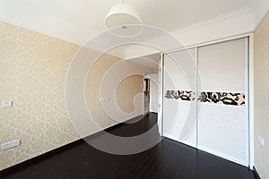 Empty bedroom with droplamp and cabinet